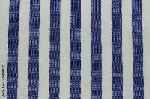Texture of blue vertical striped cotton cloth background. Close up of classic blue and white striped fabric.