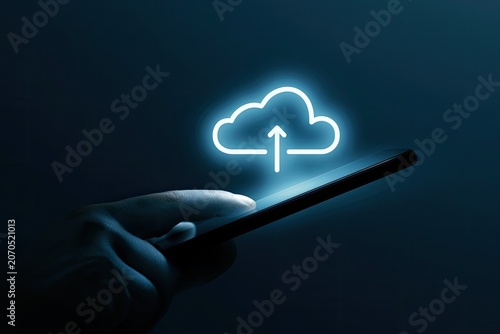Hand holding smartphone with glowing cloud upload icon