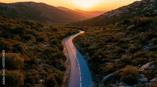 Serene mountain road winds through lush landscape at sunset