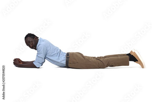 Young man lying on the ground looking at camera on white background