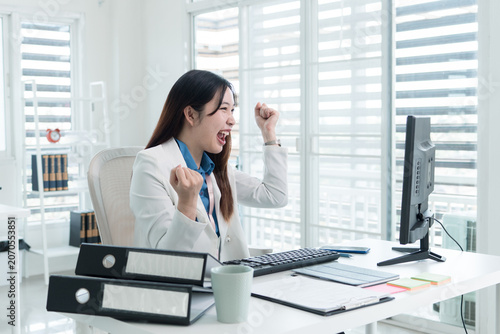 Young Businesswoman Working at Office Desk While Managing Documents and Mobile Communication.