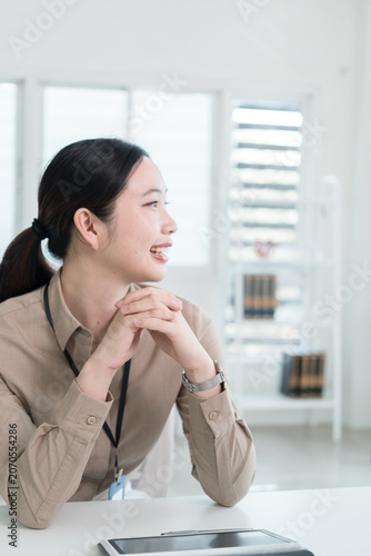 Young Businesswoman Working at Office Desk While Managing Documents and Mobile Communication.