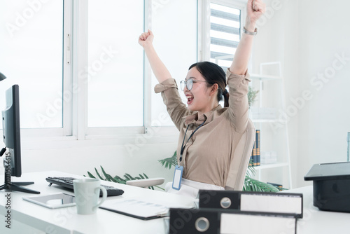 Young Businesswoman Working at Office Desk While Managing Documents and Mobile Communication.