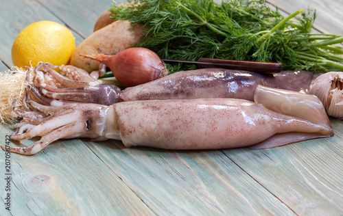 Large squids with vegetables on a wooden table close-up