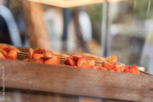 Konstfotografi fresh flaky bread decorated with ripe strawberries displayed in bakery cabinet