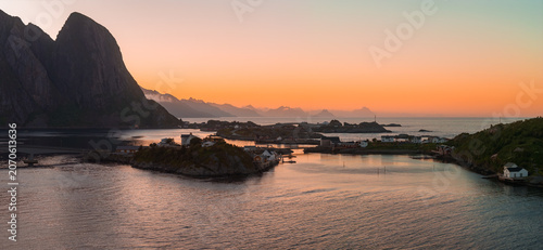 Foto Jagged granite peaks meet calm fjord waters in Lofoten Islands, Norway, near Reine or Hamnoy