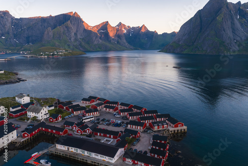 Принти на полотні Aerial scene shows red rorbuer on stilts along a calm fjord at Reine, Lofoten Islands, Norway