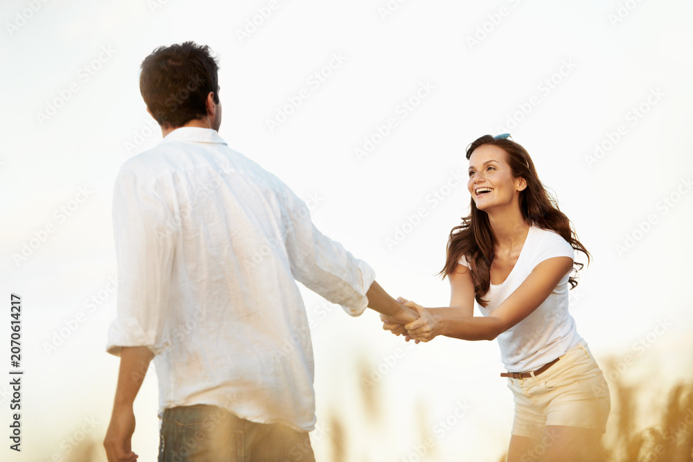 Obraz premium Couple, smile and woman holding hands in meadow, partner and support with care in nature. Female person, happiness and man outdoor for healthy relationship, bonding and together with space in Italy