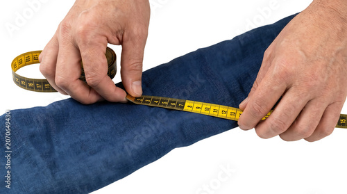 Hands measuring fabric with tape.