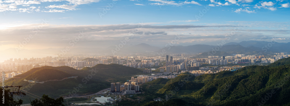 Fototapeta premium Panoramic valley and city sprawl under clear midday sky Sanya, Hainan Island, China