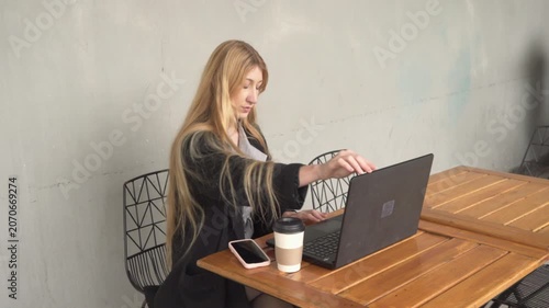 Young businesswoman working on laptop in a cafe