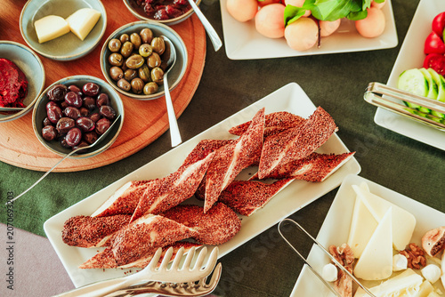 traditional turkish breakfast feast with rich variety on table photos series, simit baked dough with sesame, cheese plate, boiled eggs
