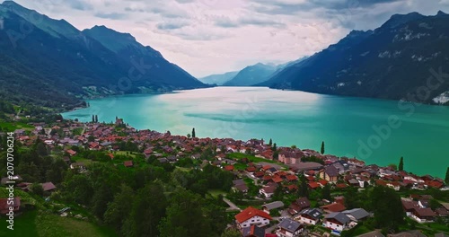 A Swiss lake with clear turquoise water. Establishing shot of Switzerland. Aerial view of Swiss