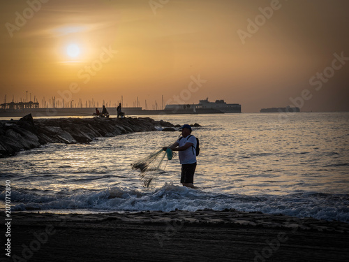 Fishermen on Pinedo beach (Valencia, Spain) at dawn