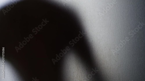 Blurred Human Silhouette Leaning Against Frosted Glass on a Grainy Translucent Surface. Isolation, Fear, Anxiety and Psychological Distress