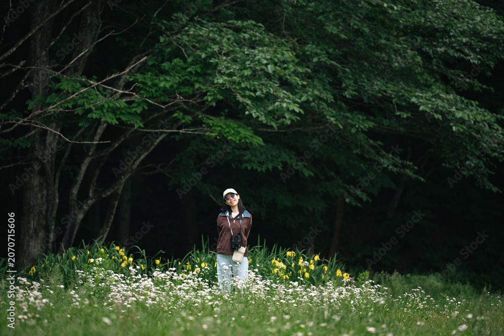 Obraz premium Woman meadow forest flower grass nature outdoor summer green white, woman standing in wildflower meadow near dark forest edge with calm expression, surrounded by green grass and yellow flower