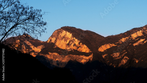 Foto Golden Sunrise on Mountain Range with Silhouetted Foreground