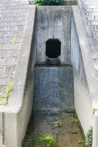 Concrete drainage outlet in river embankment