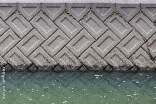 Concrete embankment wall and river water texture