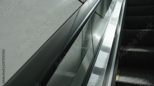 Modern Escalator Handrail and Steps Moving Downwards in an Urban Building.