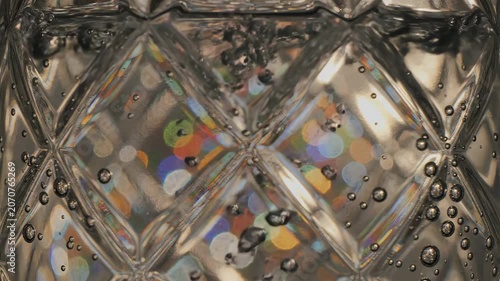 Mesmerizing Abstract View Through Patterned Glass with Trapped Bubbles and Vibrant Bokeh Lights.