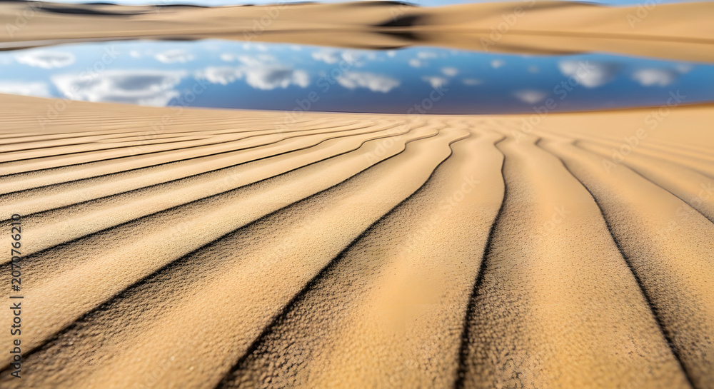 Naklejka premium Desert landscape with sand dunes and reflective water under a blue sky