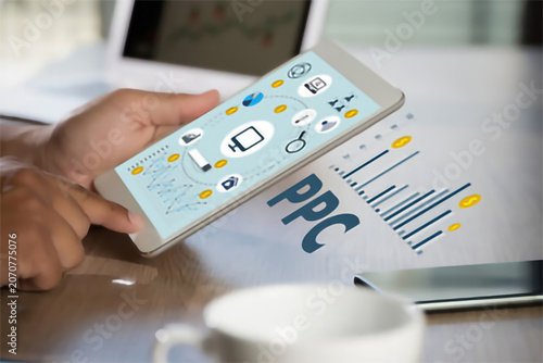 Hands interacting with digital marketing analytics and pay per click advertising data on a modern touchscreen tablet device