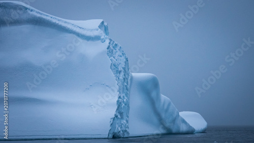 Tableau sur toile Close-Up of Fractured Antarctic Iceberg Face with Overhanging Ice Shelf