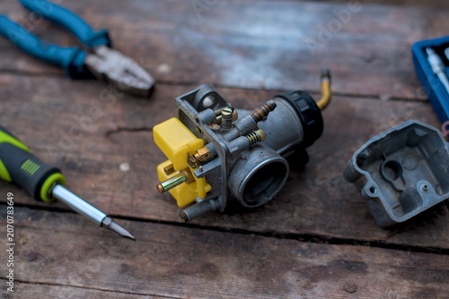 Photo of disassembled carburetor on wooden table