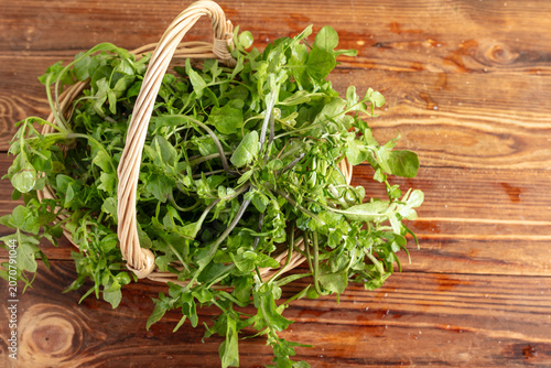 Basket of Fresh Greens on Rustic Wood Background