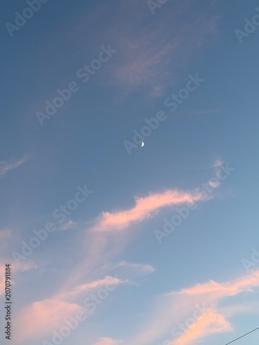 Photography pink clouds and the moon  in the sky during a beautiful sunset.