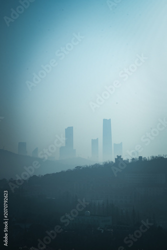 Hazy City Skyline Behind Hills
