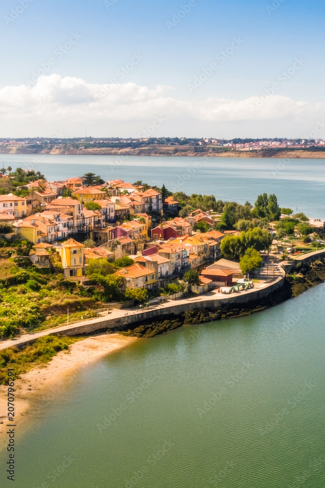 Fototapeta premium A small town situated on the edge of a large body of water, perfect for use in travel or tourism visuals vertical frame