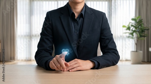 Businessman in suit interacting with holographic medical heart icon on transparent digital glass display for health insurance concept