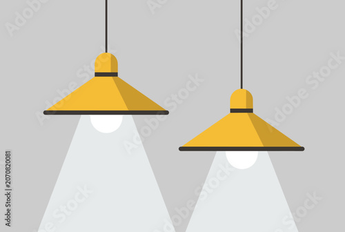 Pair of modern yellow industrial hanging pendant lamps casting cones of bright light against a neutral grey background.