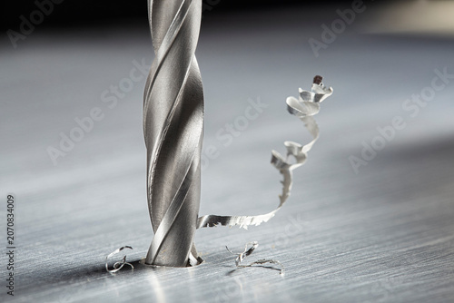 drill bit make hole in metal aluminum plate with chip. Locksmith work. Industry of construction.