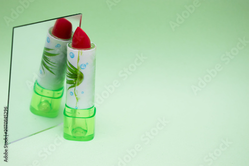Pink lipstick with daisy flower on pastel background