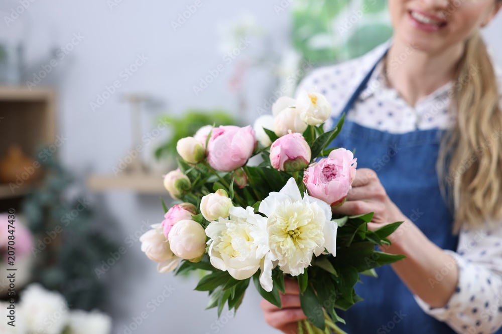 Fototapeta premium Florist making bouquet of beautiful peonies in shop, closeup. Space for text