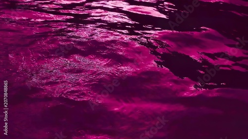 Vivid pink and purple water reflections on a dark surface