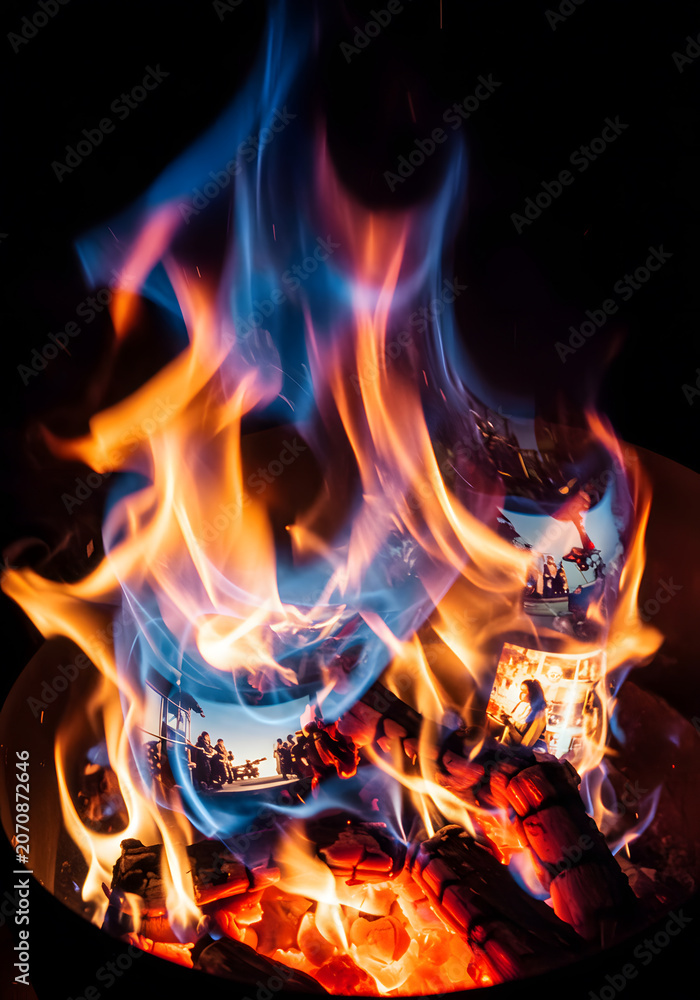 Fototapeta premium Dynamic blue and orange flames burn intensely in a fire pit, with superimposed images of people creating a nostalgic and ethereal visual.