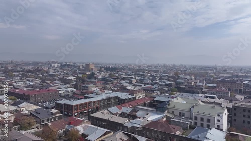 Aerial drone shot of the beautiful city of Gyumri in Armenia, showcasing its historic architecture, busy city squares, streets, and the famous landmark Holy Saviour's Church during autumn.

