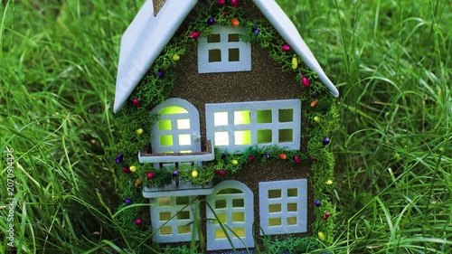 Among the dense greenery there is a fairytale decorated house with a white roof