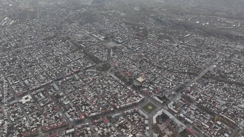 Aerial drone shot of the beautiful city of Gyumri in Armenia, showcasing its historic architecture, busy city squares, streets, and the famous landmark Holy Saviour's Church during autumn.

