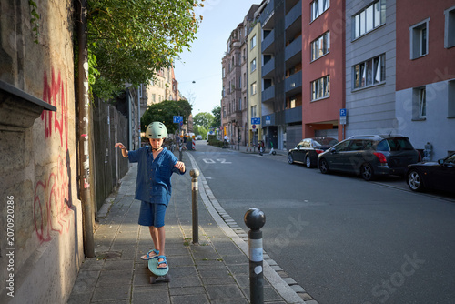 Child skateboarding on a city sidewalk during a sunny day