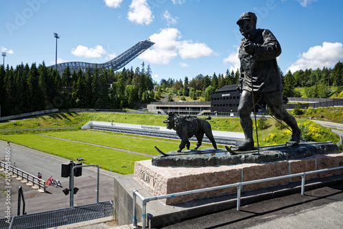 Holmenkollen: King Olav V Skiing Statue with Iconic Ski Jump Background