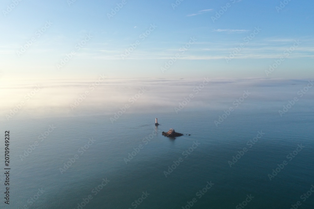 Fototapeta premium Aerial View of Coastline with Clouds and Distant City, Xiamen China