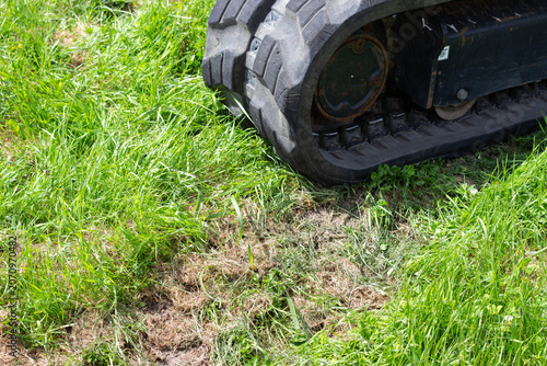 Photos Heavy machinery track on green grass surface showing soil disturbance and tire t