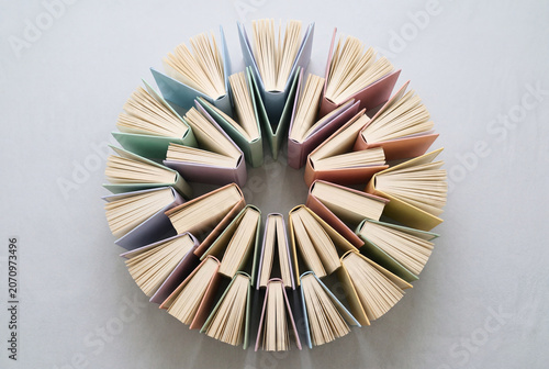 Circular arrangement of pastel colored open books standing on edge