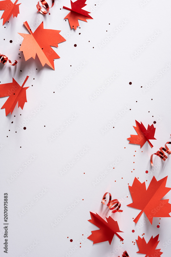 Obraz premium Canada Independence Day celebration with red paper maple leaves and confetti on vertical white background