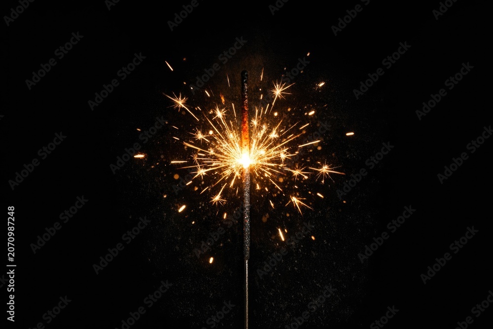 Fototapeta premium Close-up shot of a single sparkler on a dark, black background